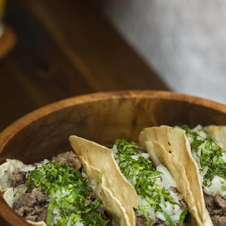 Tacos de carnitas con cebollita y tortillas hechas a mano