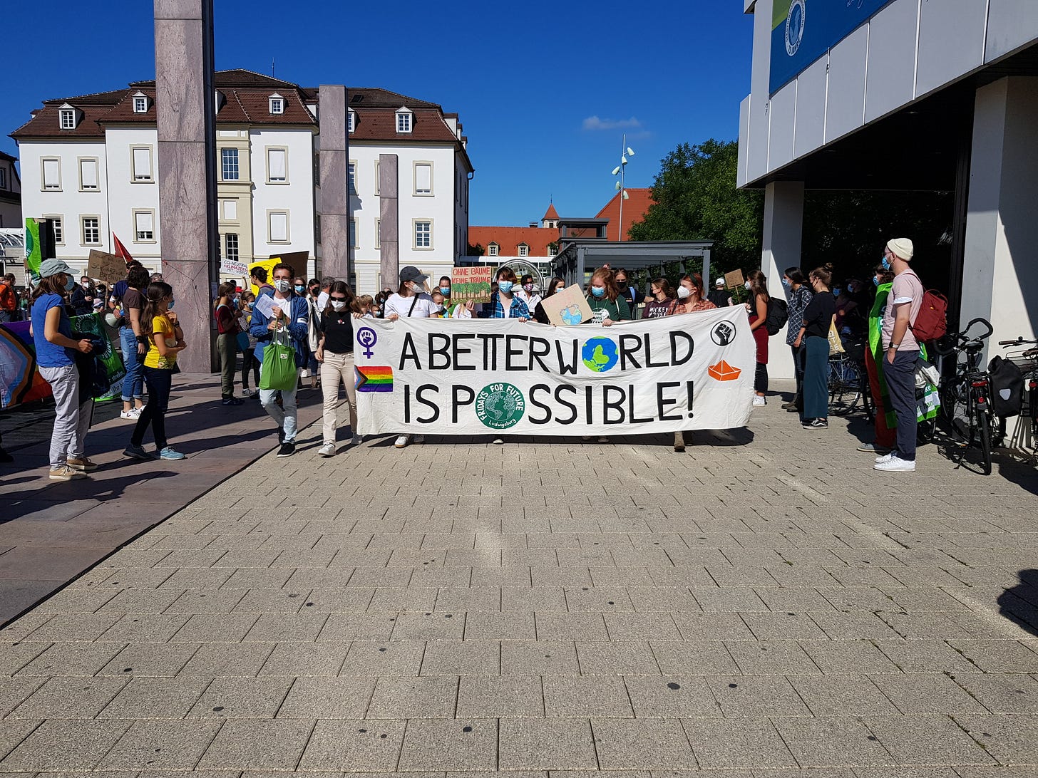 Protesters handing up a banner saying "A better world is possible"