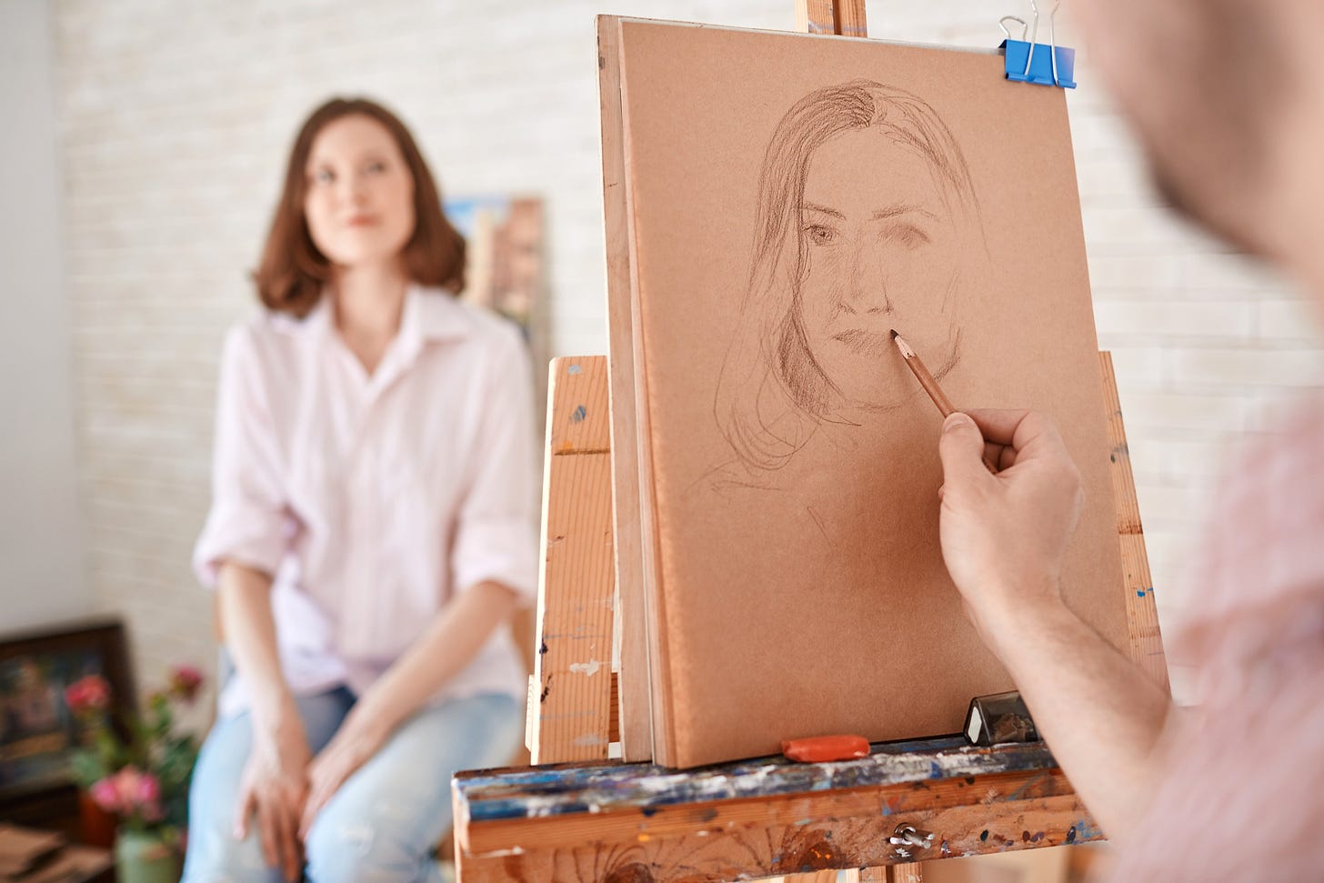 Artist sketching a young woman.