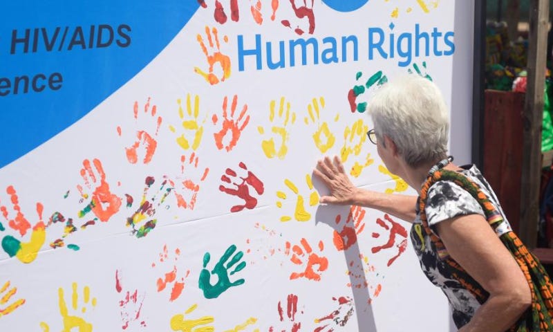 A woman applies paint to a banner during a public event to commemorate the Human Rights Day in Gaborone, Botswana on Dec. 9, 2022. Human Rights Day is observed every year on Dec. 10 - the day the United Nations General Assembly adopted in 1948 the Universal Declaration of Human Rights. (Photo by Tshekiso Tebalo/Xinhua)