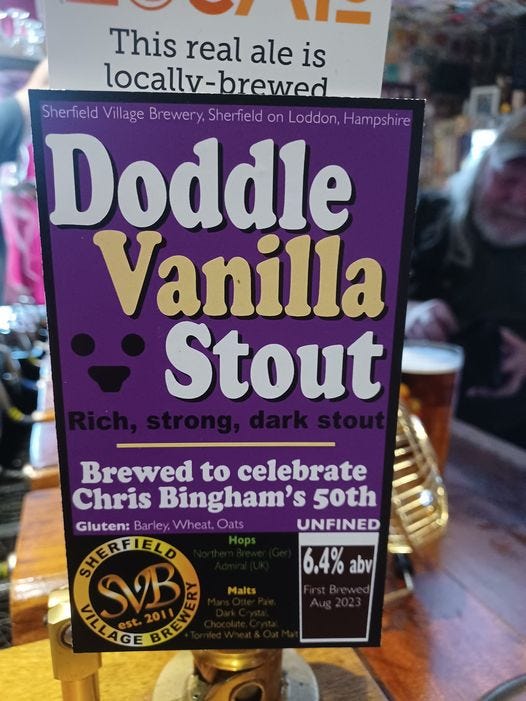 May be an image of ale and text that says "This real ale is locallv-brewed brewed Sherfield Village Brewery, Sherfield on Loddon, Hampshire Doddle Vanilla Stout Brewed to celebrate Chris Bingham's 50th Gluten: Barley, Wheat, Oats UNFINED SHERFIELD ELD 6.4% abv SVB VILLAGE Malts"