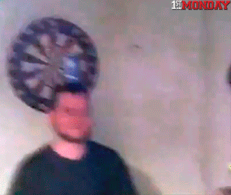 Man standing in front of a dartboard with a can on his head, representing risky stock investing without research or strategy.