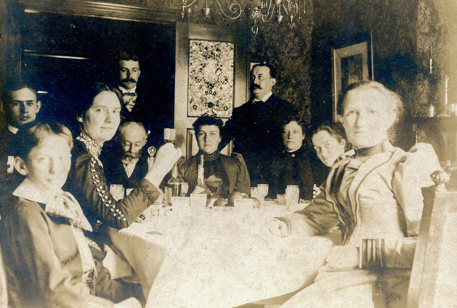 People gathered around a table with bottles of liquor