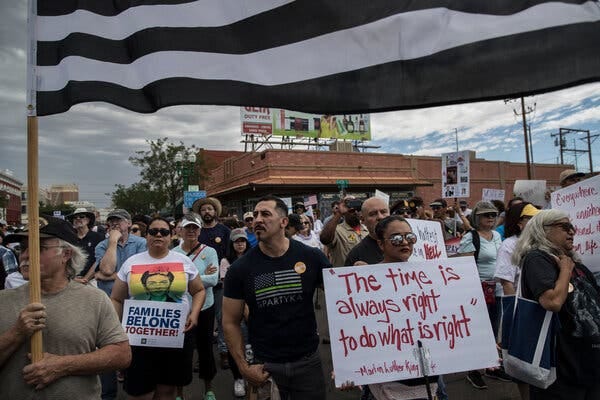 Demonstrators, carrying signs and a flag, gather in El Paso, in 2018 to protest family separations.