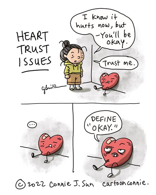 Heart Trust Issues 3-panel comic of a cartoon girl with a bun talking to a cartoon heart character, drawn with facial features and legs. In panel 1, the heart is slumped against an interior wall, bandaged and a bit bruised. The girl tries to reassure the heart: "I know it hurts now, but - you'll be okay. Trust me." In panel 2, a silent beat, while the heart thinks this over. In panel 3, the heart looks up distrustfully and demands more information: "Define 'okay.'" Cartoon titled "Heart Trust Issues" by Connie Sun, cartoonconnie, 2022.