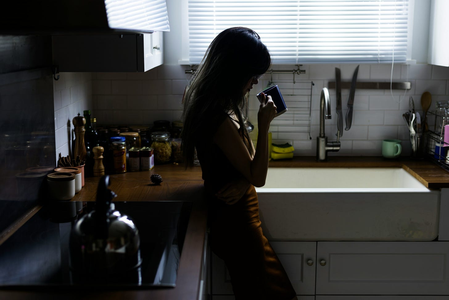 Woman in kitchen with coffee.
