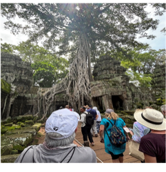 A group of people standing in front of a tree A group of people standing in front of a tree