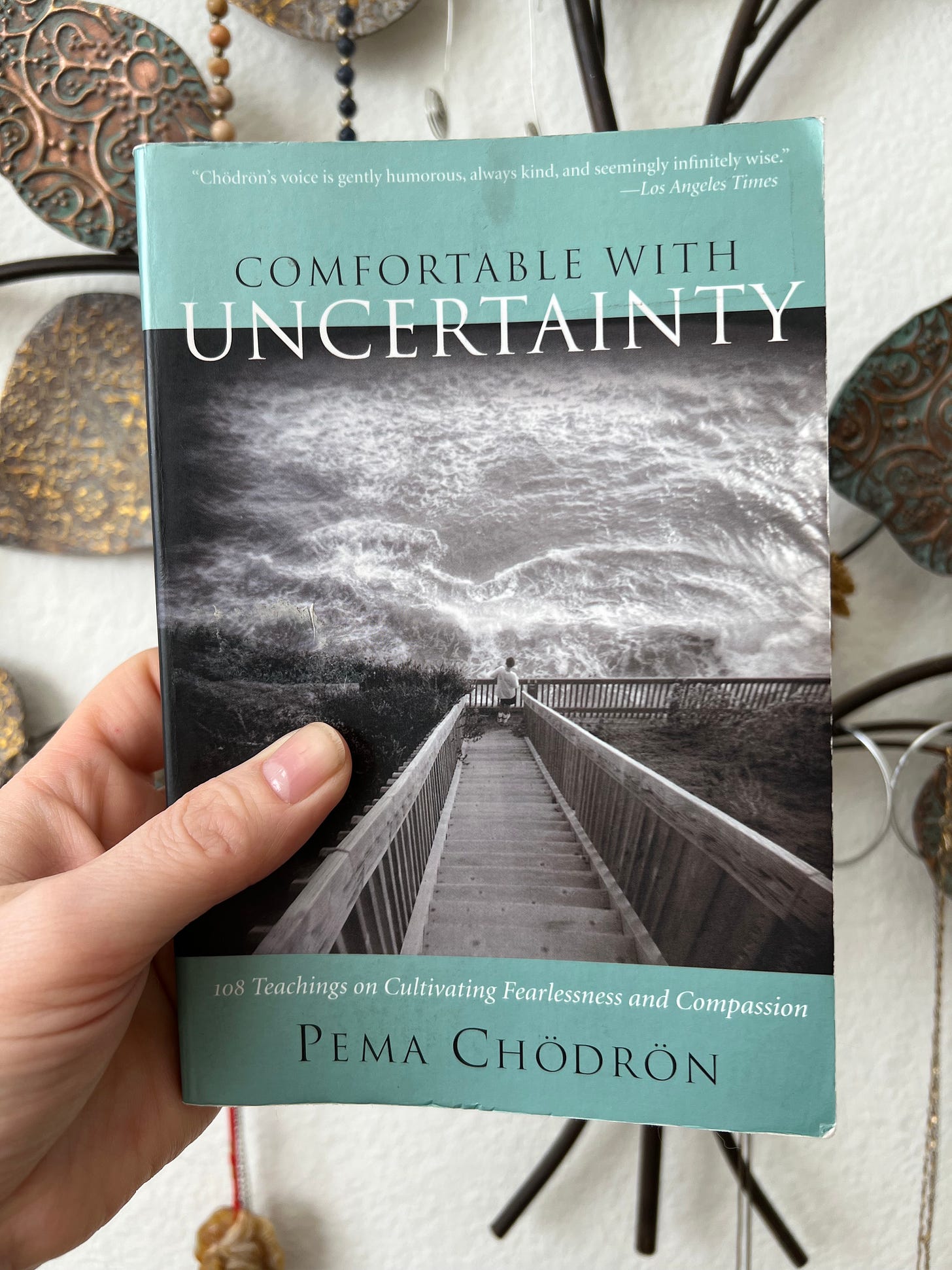 Erin holds a copy of Comfortable with Uncertainty by Pema Chodron