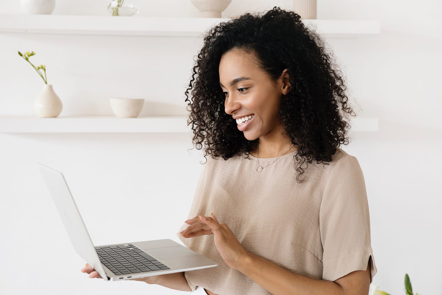 Woman using her laptop and smiling on white background