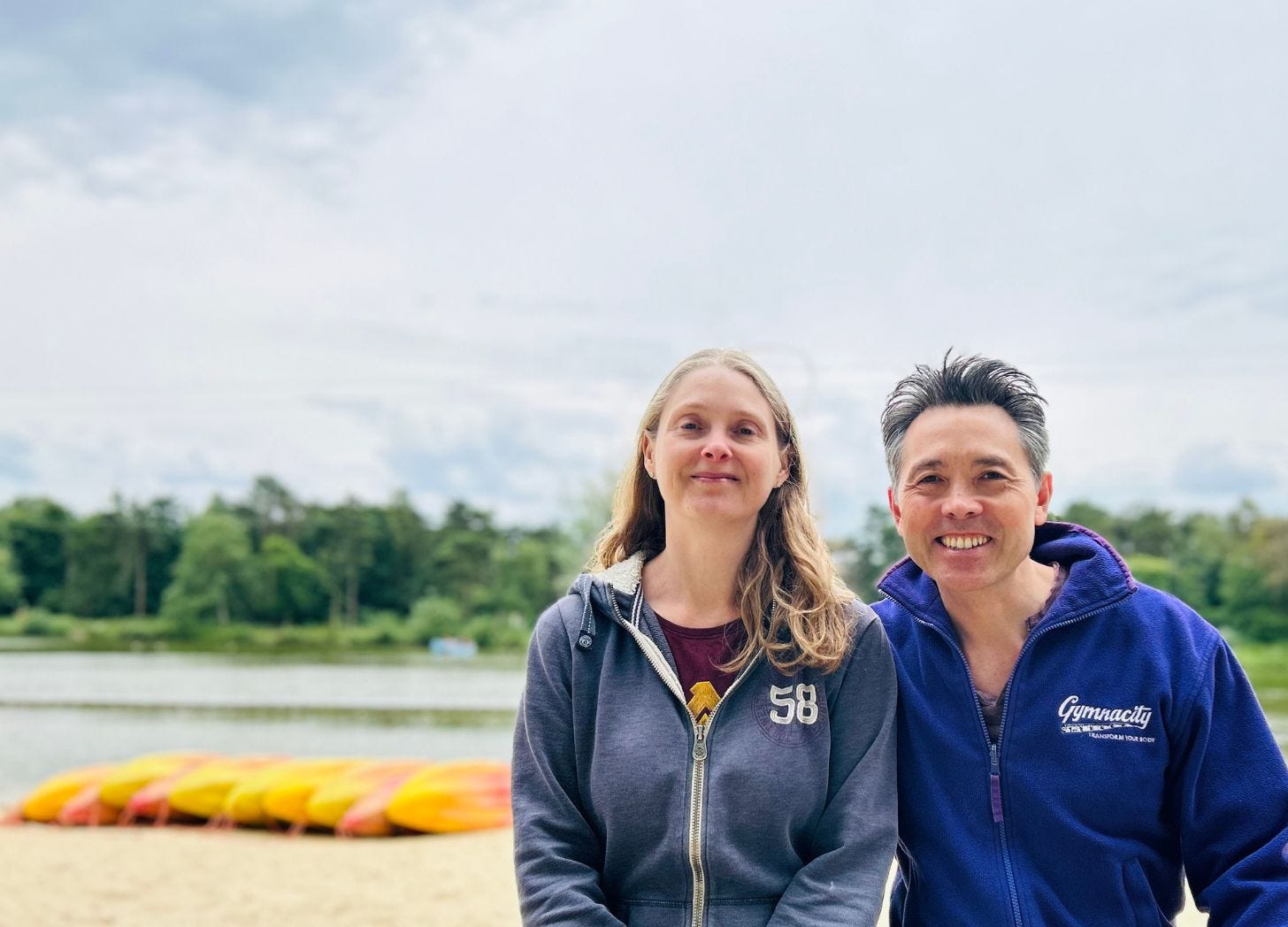 man and woman sitting by lake and kyaks at Center Parcs Elveden Forest https://sarahandgeorge.co.uk