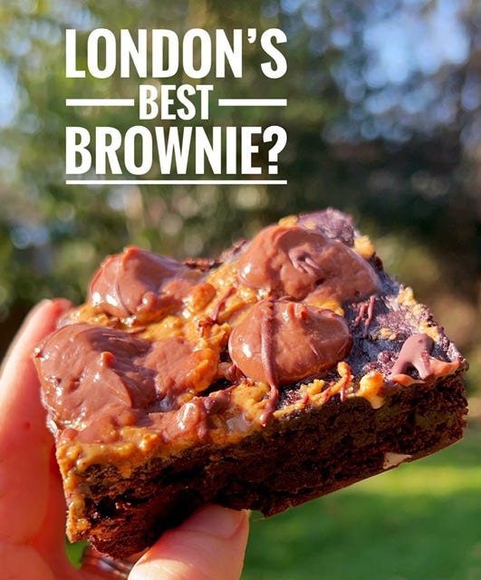 vegan peanut butter and chocolate brownie with chocolate mousse topping held up against a nature background with the text "London's Best Brownie?" in white.