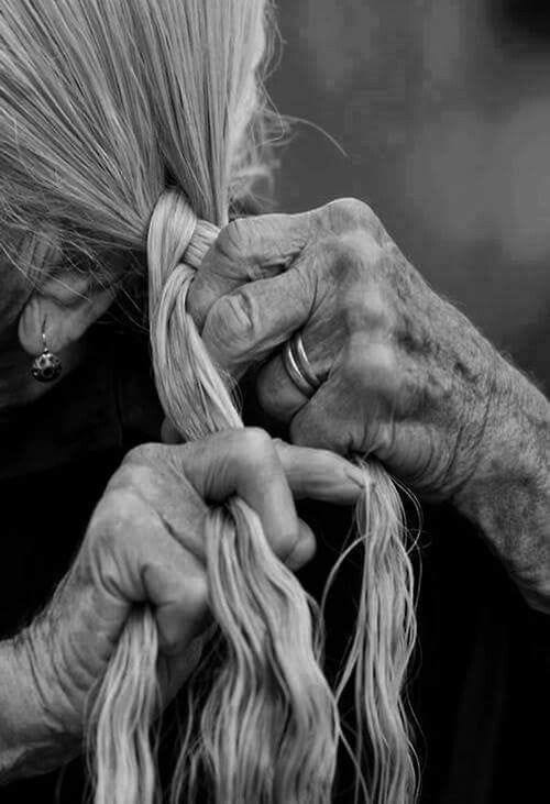 This may contain: an old woman is braiding her hair in black and white, with the caption ompabaka com