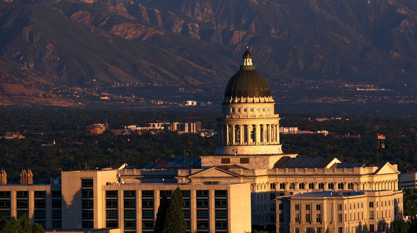 Utah Capitol with forested mountains in background