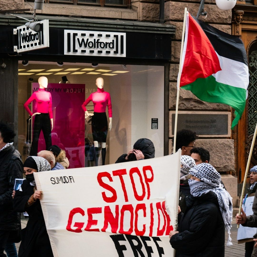 a group of people walking down a street holding signs