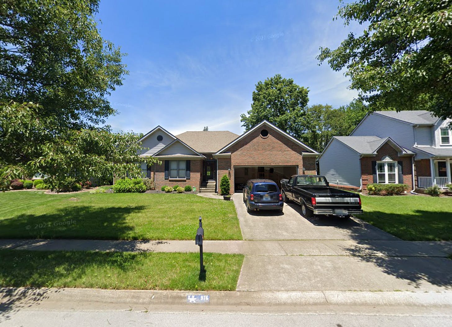 A typical low-rise single-family home set back beyond a lawn and with a two-car garage.