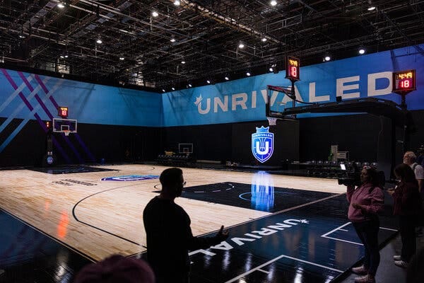 A basketball arena with the word “Unrivaled” in large lettering on a wall above the court.