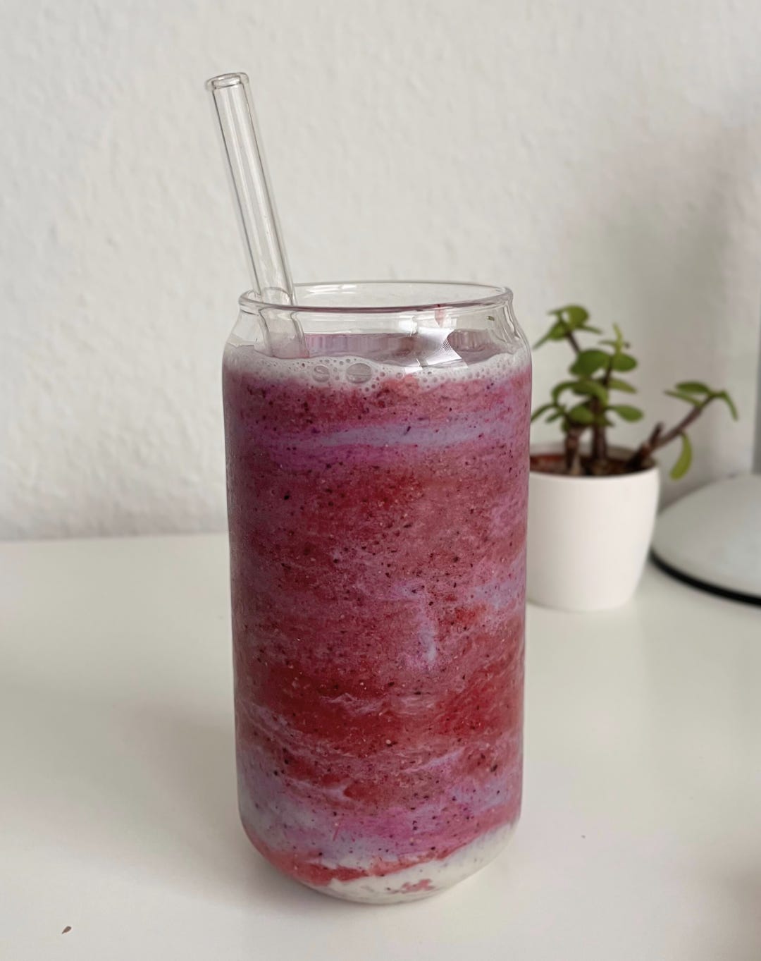 A vibrant glass of Banana Berry Smoothie, layered with creamy almond milk and swirled for a marbled effect, garnished with fresh berries and a sprinkle of chia seeds.