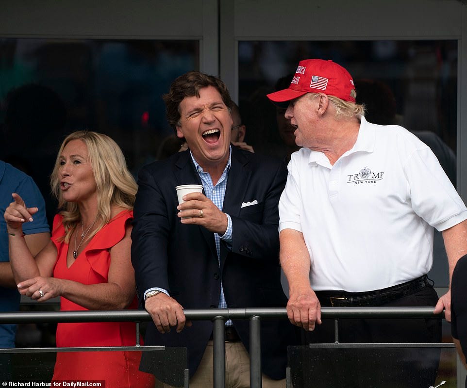 Trump and Tucker Carlson laugh as chants of Let's go Brandon ring out across Bedminster golf ...