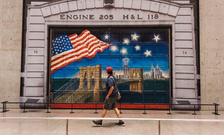 A walker looks at a mural outside the 9/11 Memorial Pools and Museum in NYC.