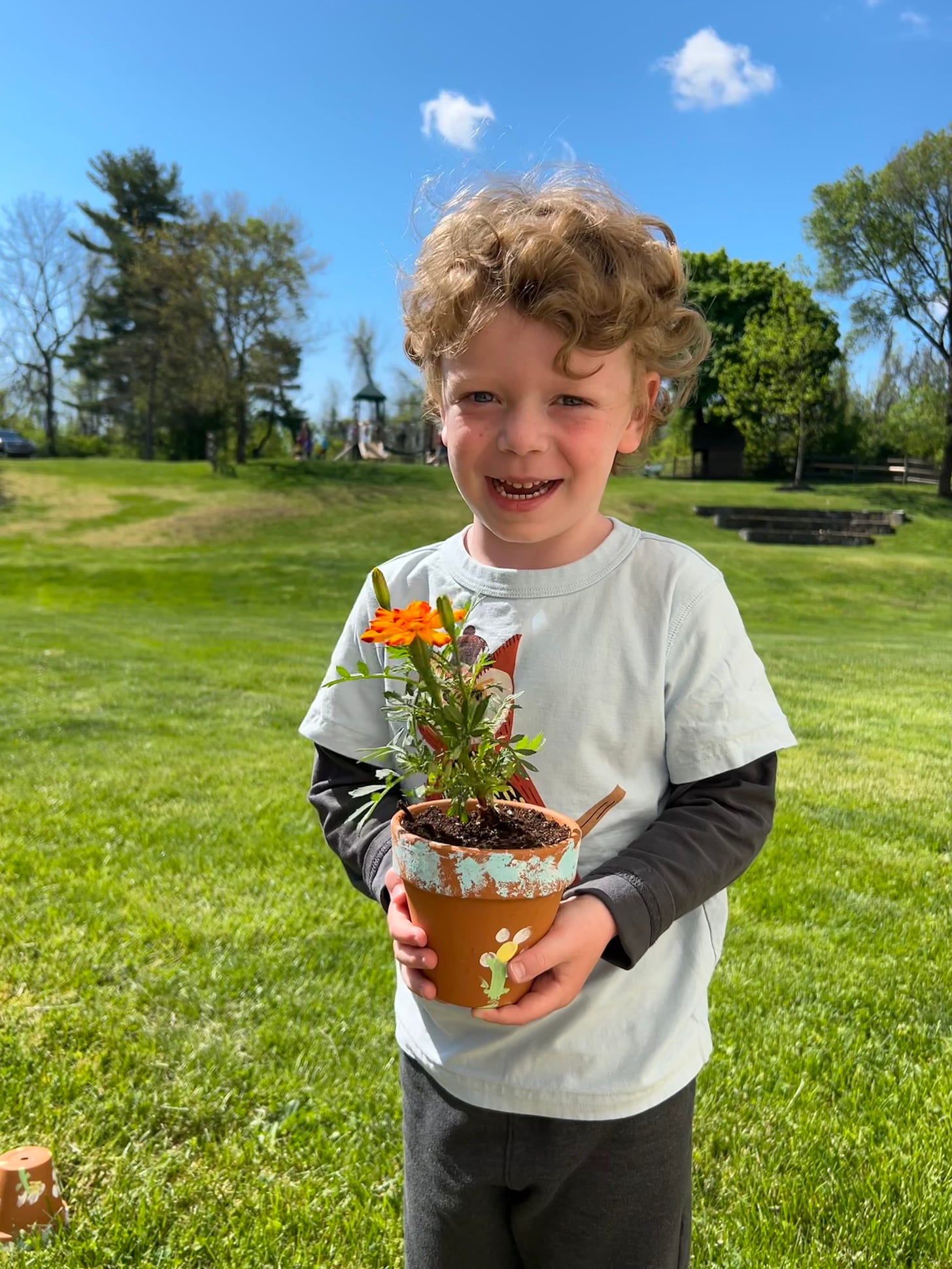 Jagger holding a marigold in a clay pot