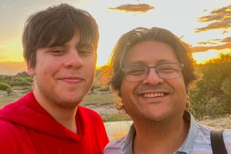 Suleman Dawood, 19, and his father Shahzada, 48 smiling in front of sun set
