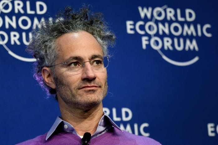 Alex Karp in front of a backdrop with the World Economic Forum logo on it.