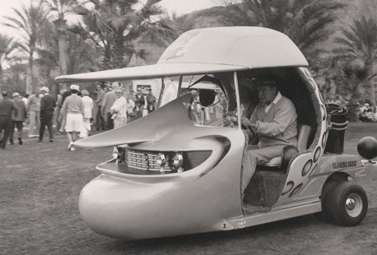 Bob Hope driving a golf cart in the shape of Bob Hope's face