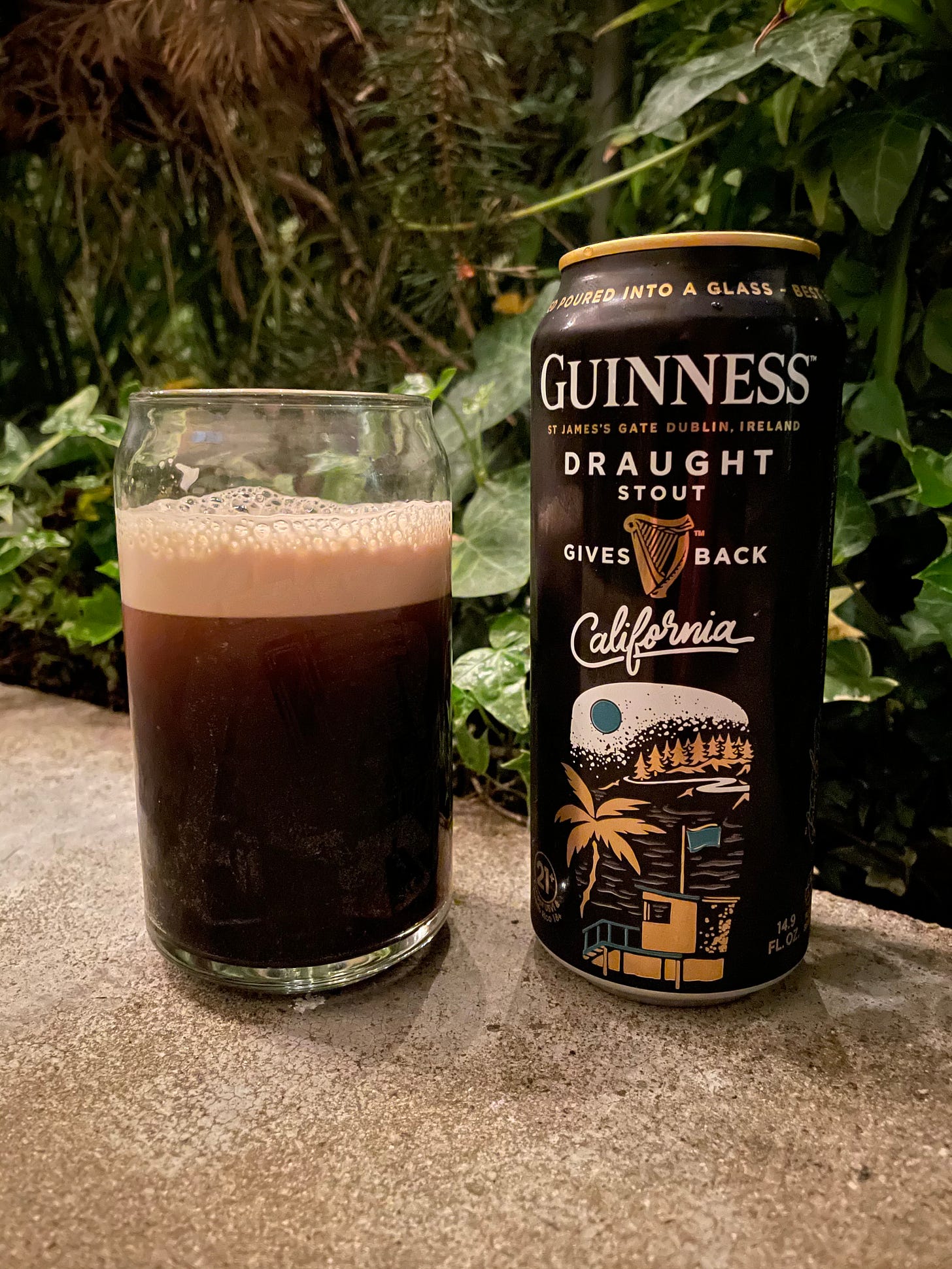 A glass of Guinness Stout next to a can of Guiness with California on the label