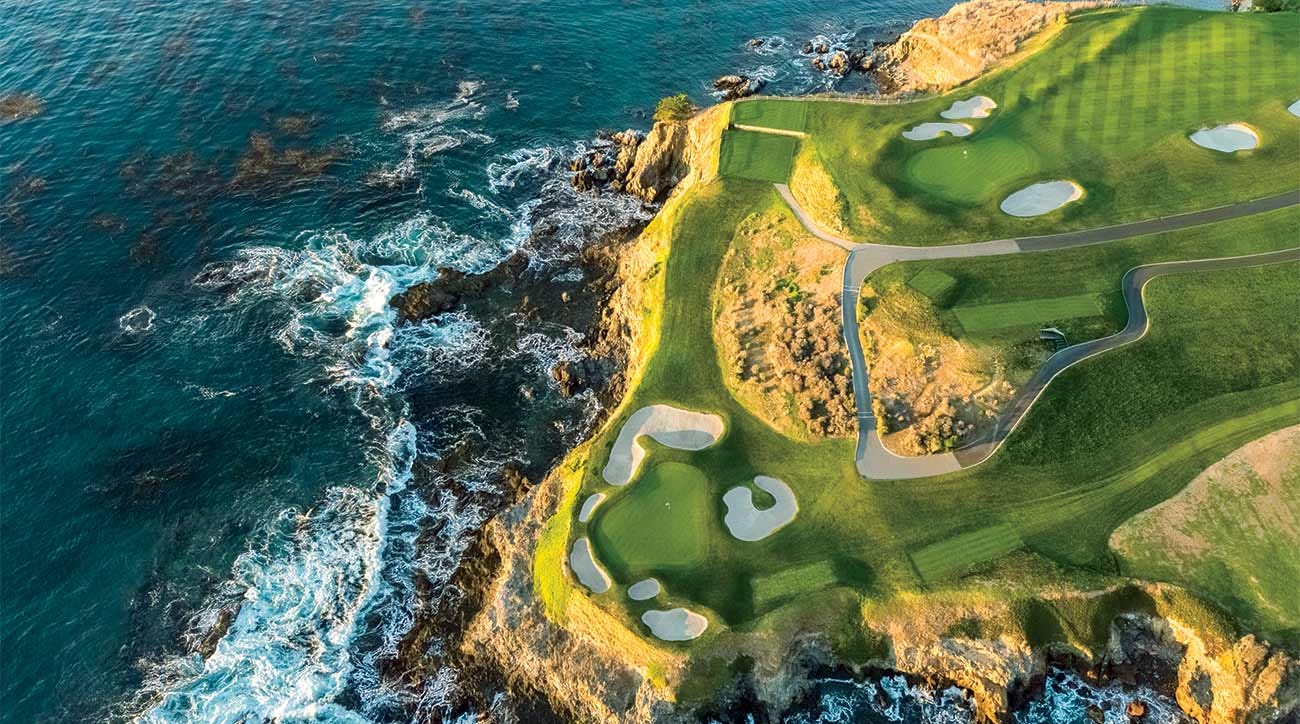 Aerial view of a dramatic coastal golf course with emerald green fairways and white sand bunkers perched atop golden cliffs. Turquoise waters of the Pacific Ocean crash against the rocky coastline below, creating a stunning contrast between land and sea. Aerial view of a dramatic coastal golf course with emerald green fairways and white sand bunkers perched atop golden cliffs. Turquoise waters of the Pacific Ocean crash against the rocky coastline below, creating a stunning contrast between land and sea.
