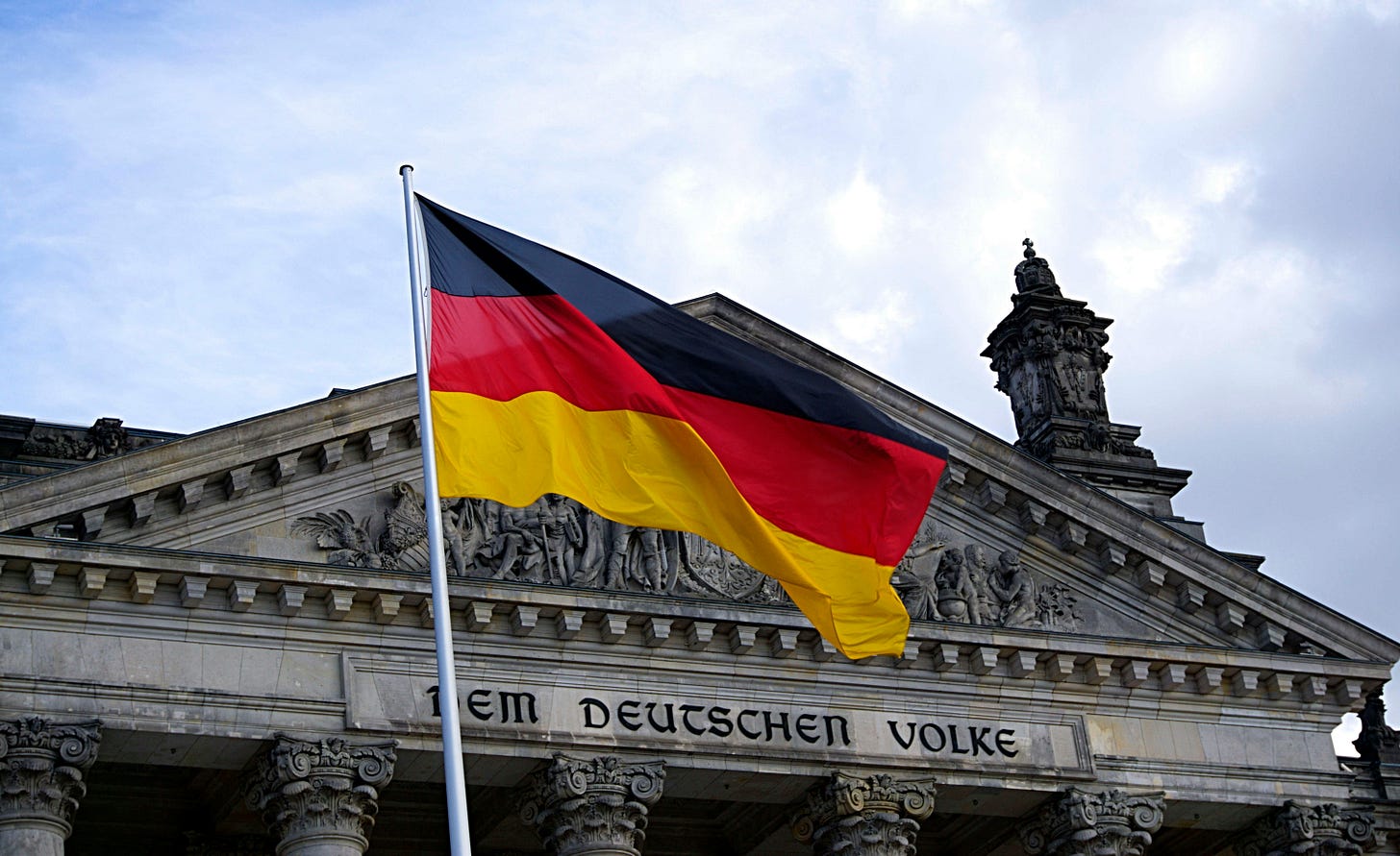 German national flag waving in front of the Reichstag building in Berlin, a symbol of democracy