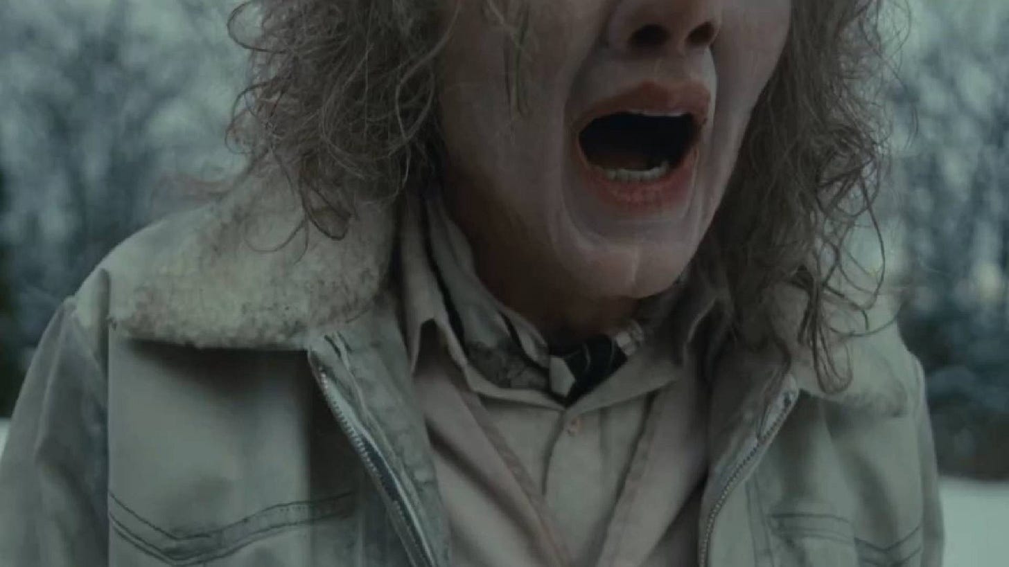 Movie still from Longlegs. An woman screams outside in the snow