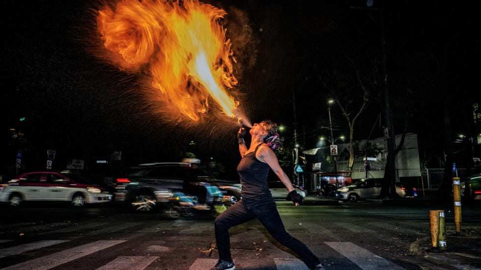 Feminist activist and street artist Flor de Fuego performs on a street in Mexico City