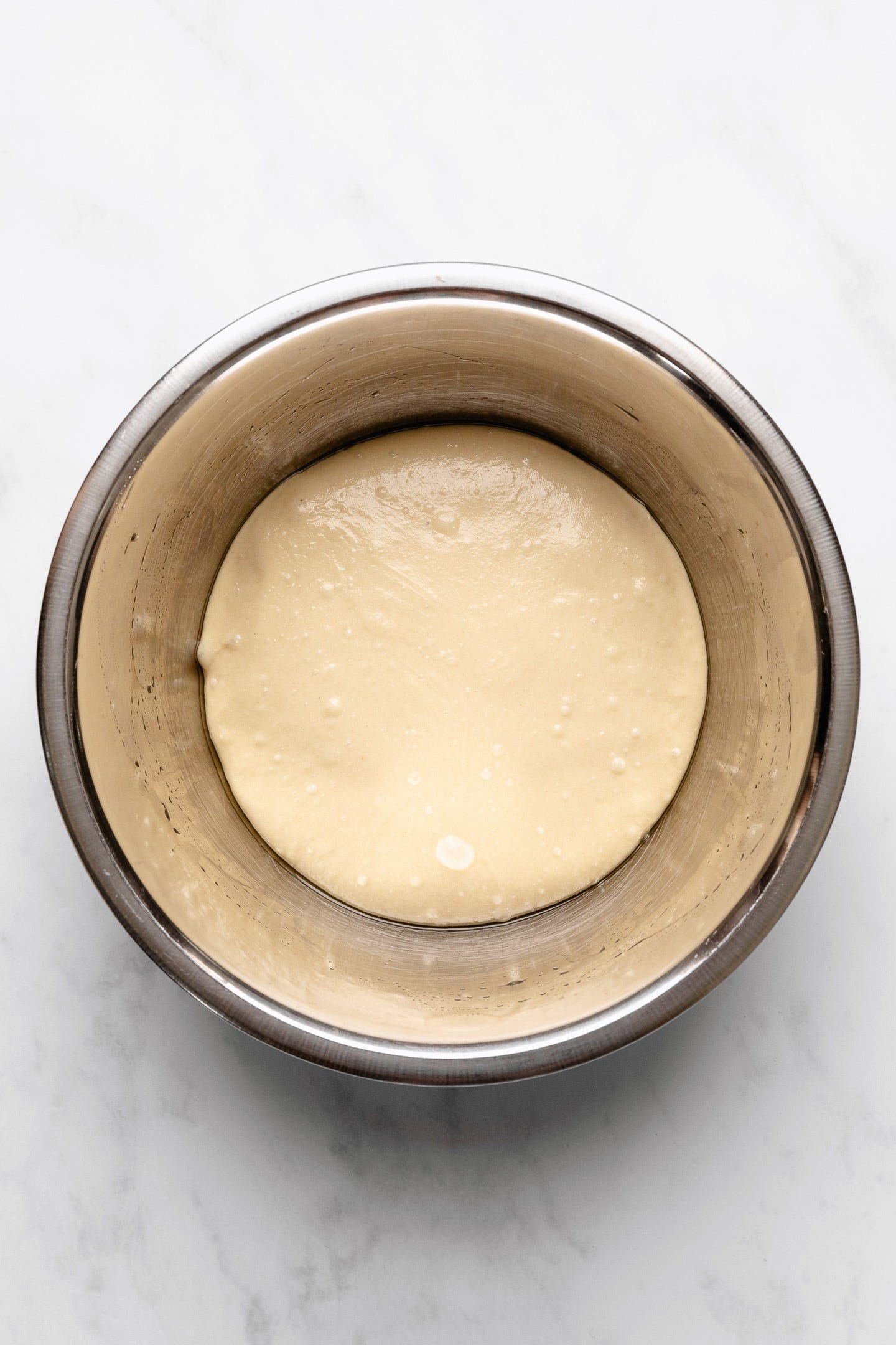 Vegan brioche dough in a stainless steel bowl