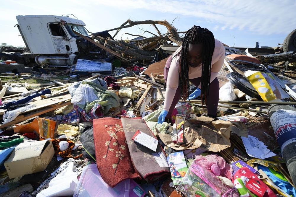 FILE - Kimberly Patton surveys through the belongings at the spot of a family member's home after a tornado destroyed the property March 26, 2023, in Rolling Fork, Miss. A new study says warming will fuel more supercells or tornados in the United States and that those storms will move eastward from their current range. (AP Photo/Julio Cortez, File)