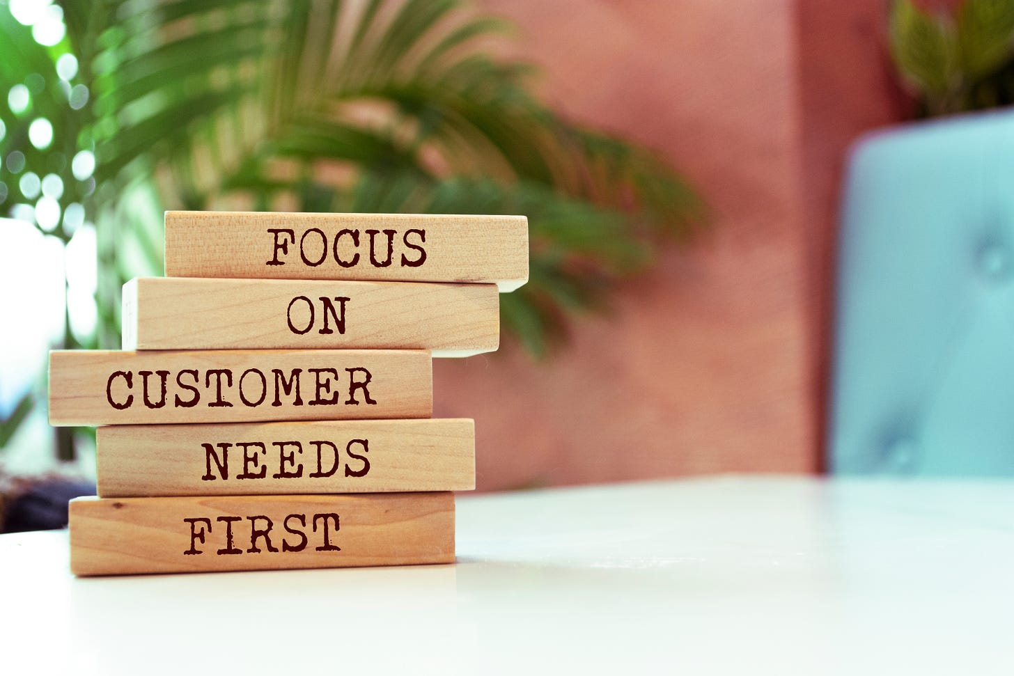 Blocks on a table that spell out "Focus on Customer Needs first"