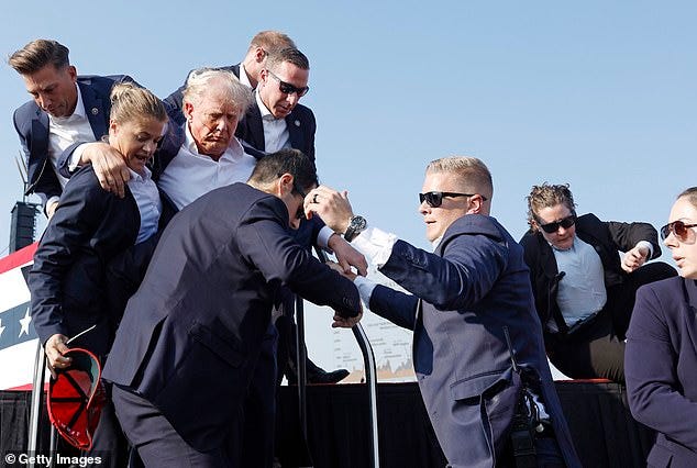 Republican presidential candidate former President Donald Trump is rushed offstage during a rally on July 13, 2024