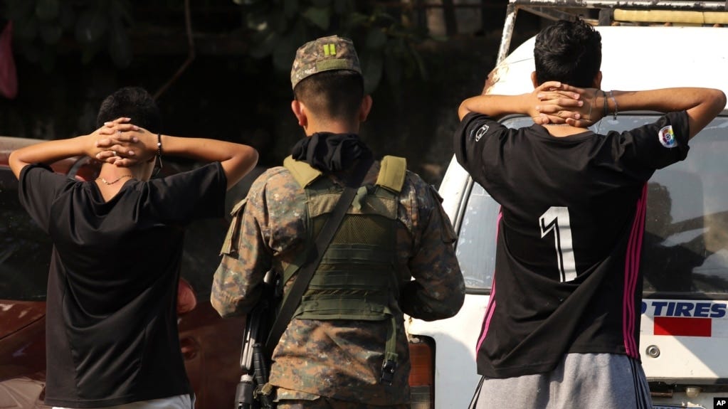 ARCHIVO - Un soldado verifica la identificación de jóvenes en la calle principal de la colonia La Campanera en Soyapango, El Salvador, 5 de marzo de 2023. El 9 de julio de 2024 se aprobó la 28ª prórroga de un estado de excepción, vigente desde marzo en 2022.