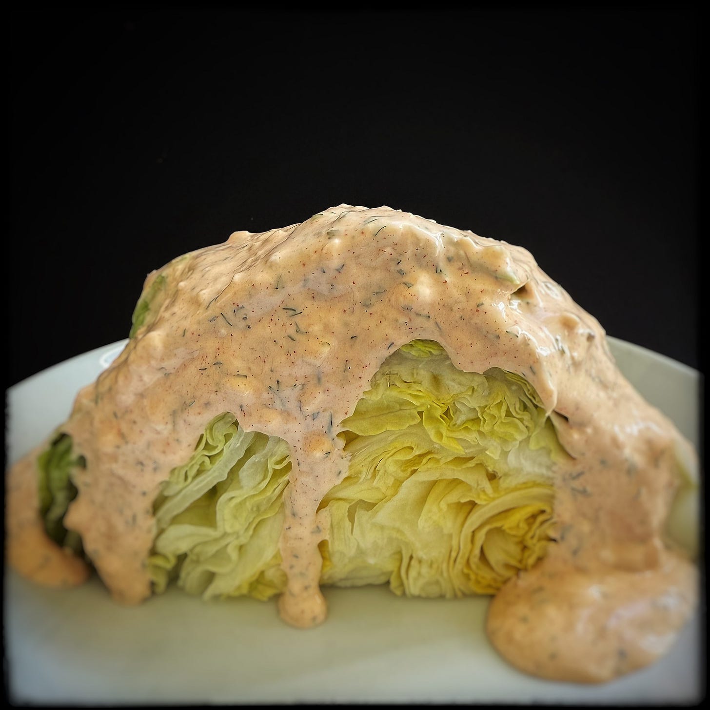 Iceberg lettuce wedge with a reasonable amount of Russian dressing poured over it. 