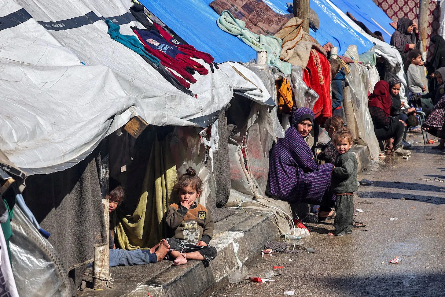 Displaced Palestinians sit outside tents in Rafah.