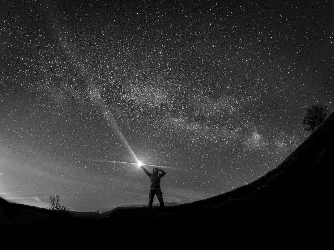 silhouette of man holding flashlight