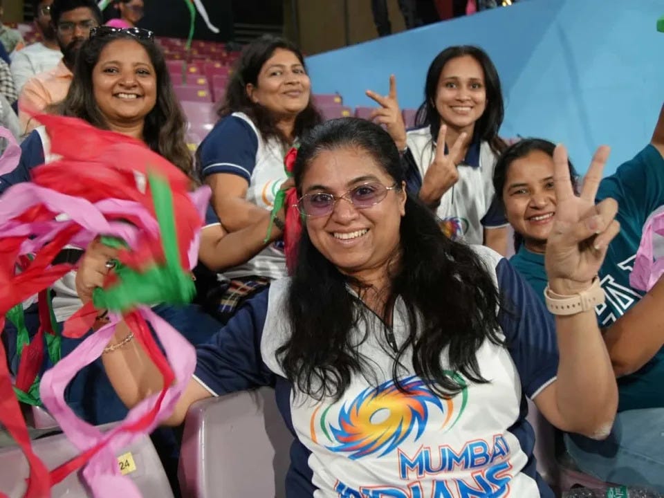A group of fans of the newly-formed Mumbai Indians women's team cheer at the first match of the inaugural Women's Premier League, a new professional cricket league in India.  (Salimah Shivji/CBC - image credit)