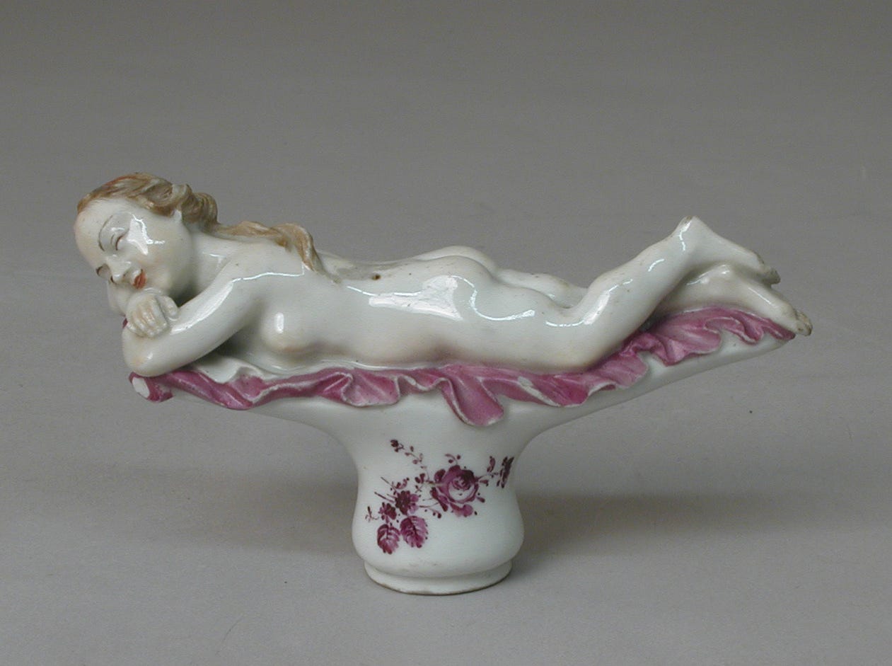 Ceramic cane handle depicting nude woman laying face down on a pink cloth