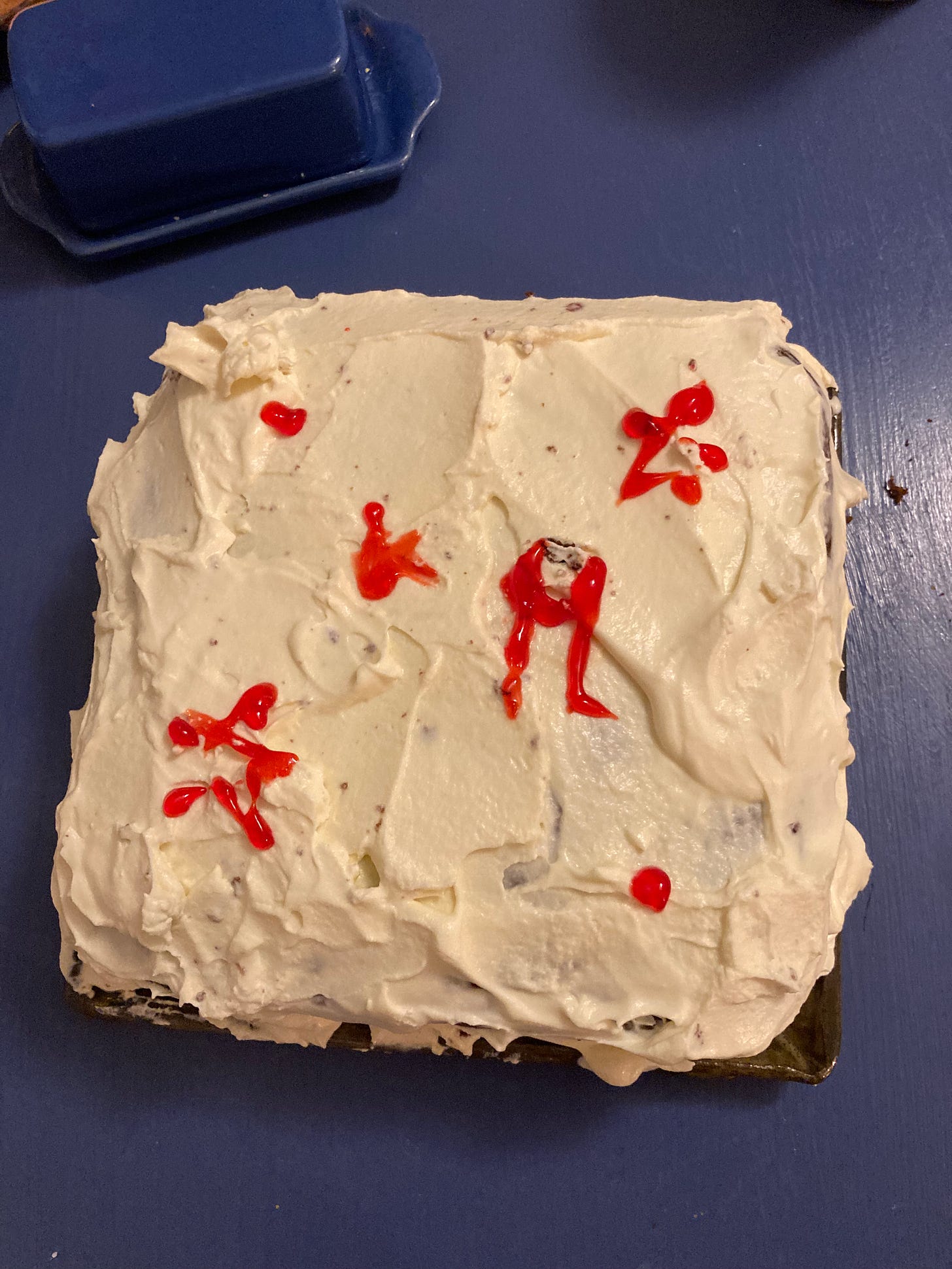 A white cake with red writing on it on a blue table. How patriotic! Photo credit: Becca Hall