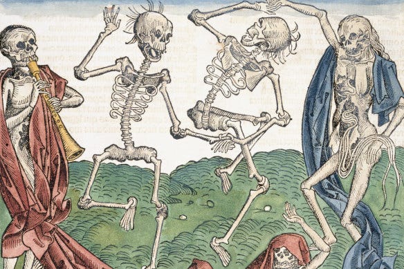 a manuscript illustration of four skeletons on a hilly green landscape; the first, from left to right, is draped in a red robe and playing what i think is a bassoon. the middle two skeletons are naked and dancing, holding hands. the last skeleton, on the right, is also dancing, but draped in a long blue robe. a single skull, draped in red, and raising a melancholy looking hand, can be seen at the bottom right.
