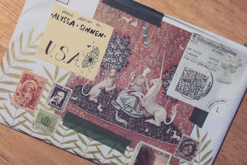 A handcrafted envelope collaged with antique photos, illustrations, postage stamps, and washi tape.