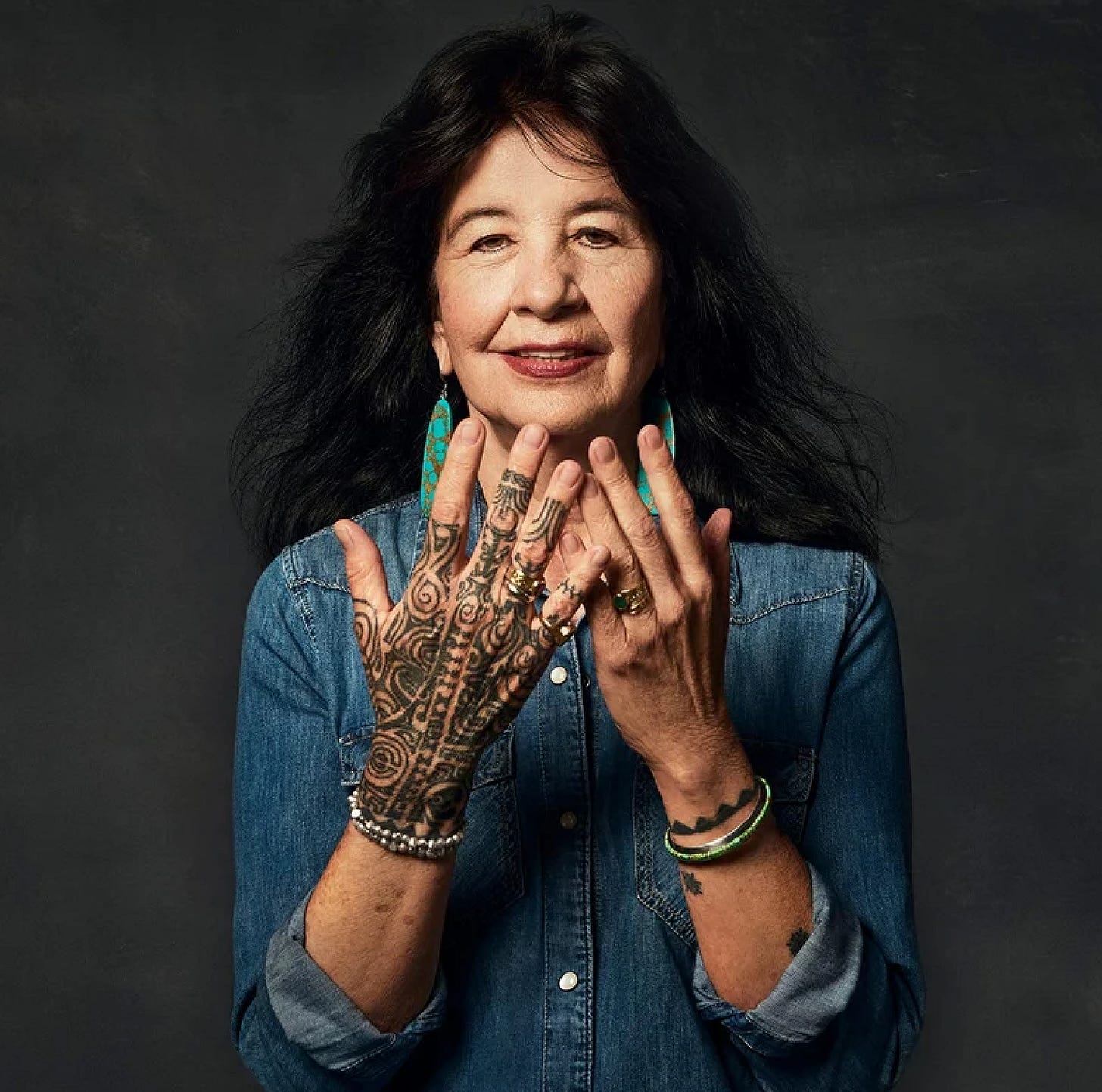 Joy Harjo, Poet Laureate showing her hands and her hair.