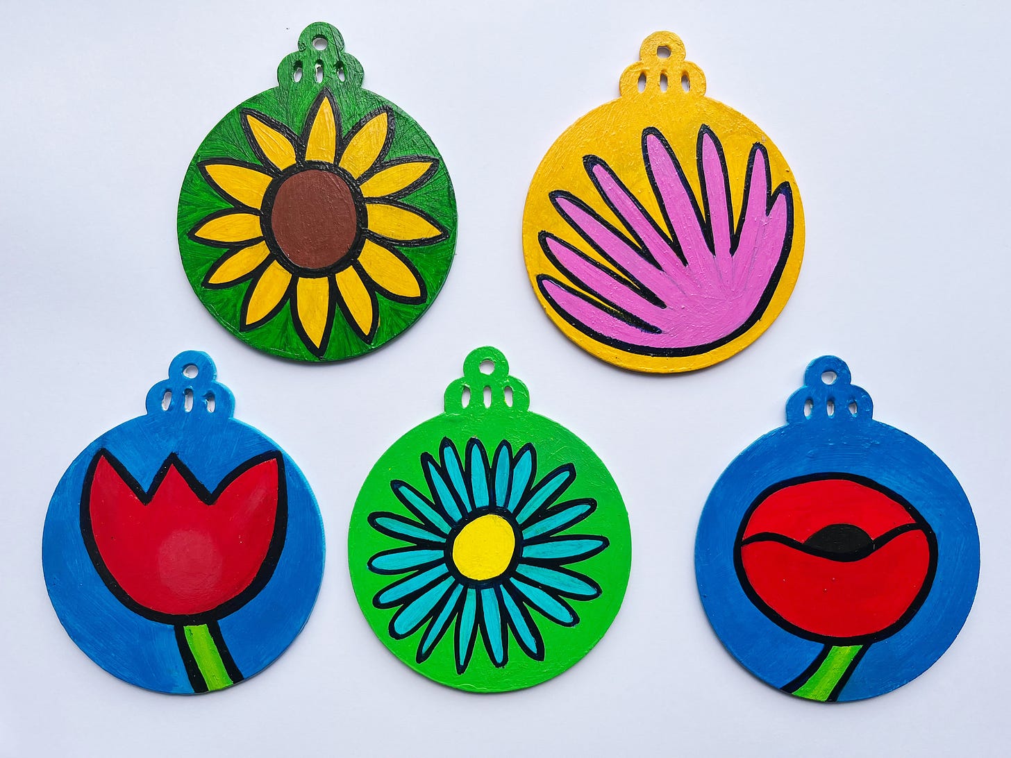 Five Christmas ornaments representing flowers