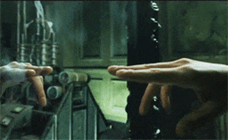 Gif clipped from the film, ‘The Matrix’ of a hand reaching out to a plane of mirror only to reveal the surface is liquid, not solid