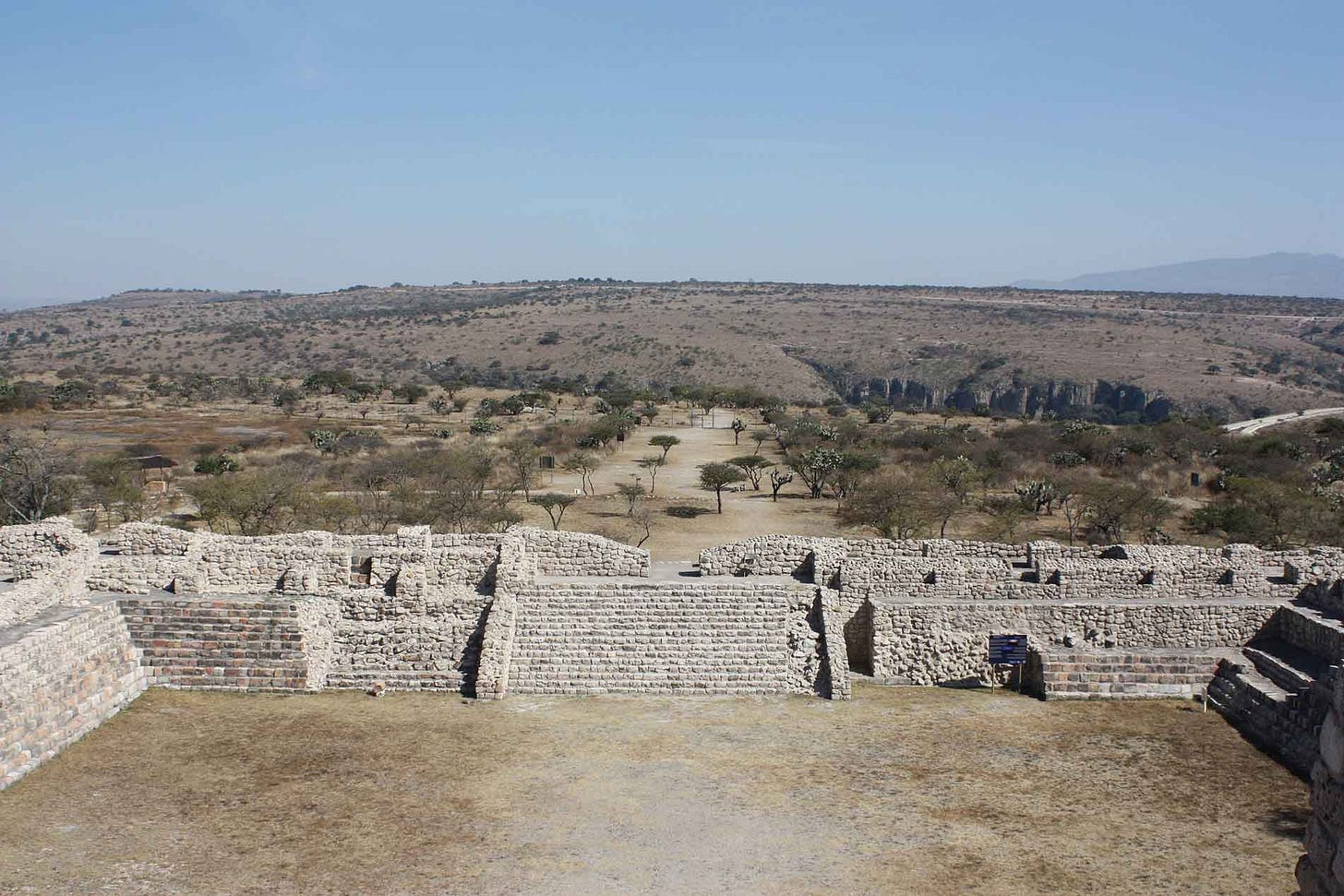 A stone tiered structure surrounded by brushland A stone tiered structure surrounded by brushland