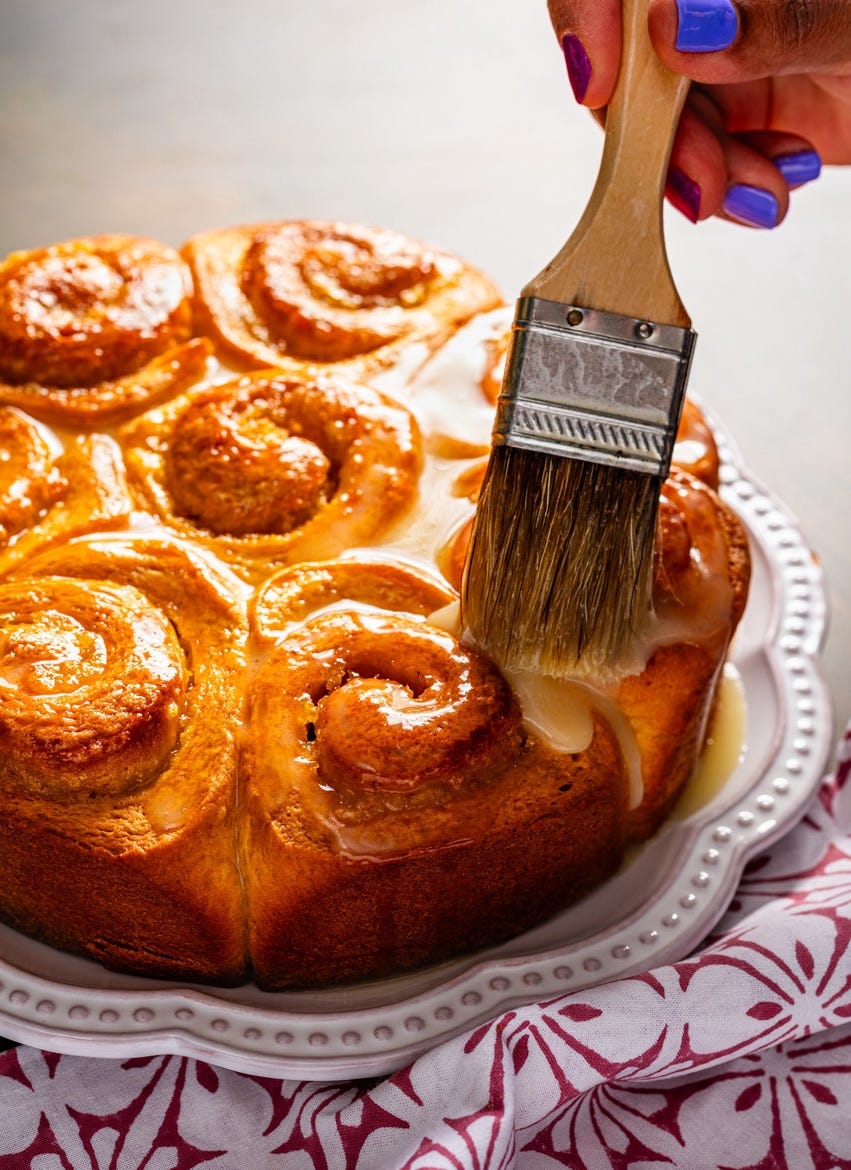 sweet orange rolls, brushing on glaze with pastry brush